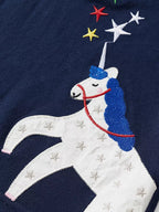 Dark navy kids polo with white unicorn appliqué and colorful embroidered stars, design close-up