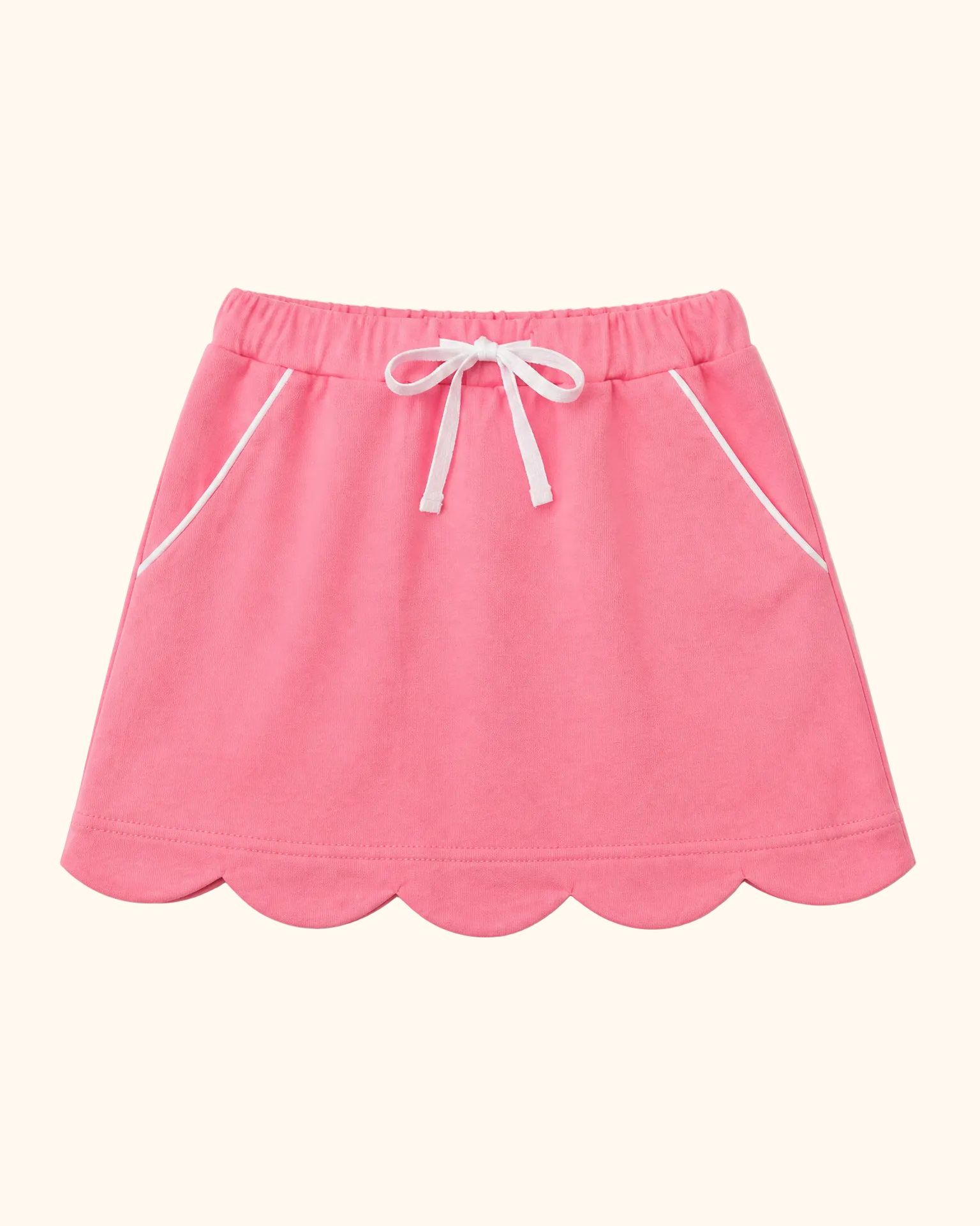 Deep pink kids skort with scalloped hem, white waist bow and piped front pockets, front view