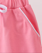 Deep pink kids skort with white-piped front pocket, pocket detail close-up