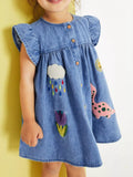 Denim kids A-line dress with dinosaur, rain cloud, flower and sun appliqués, front model view