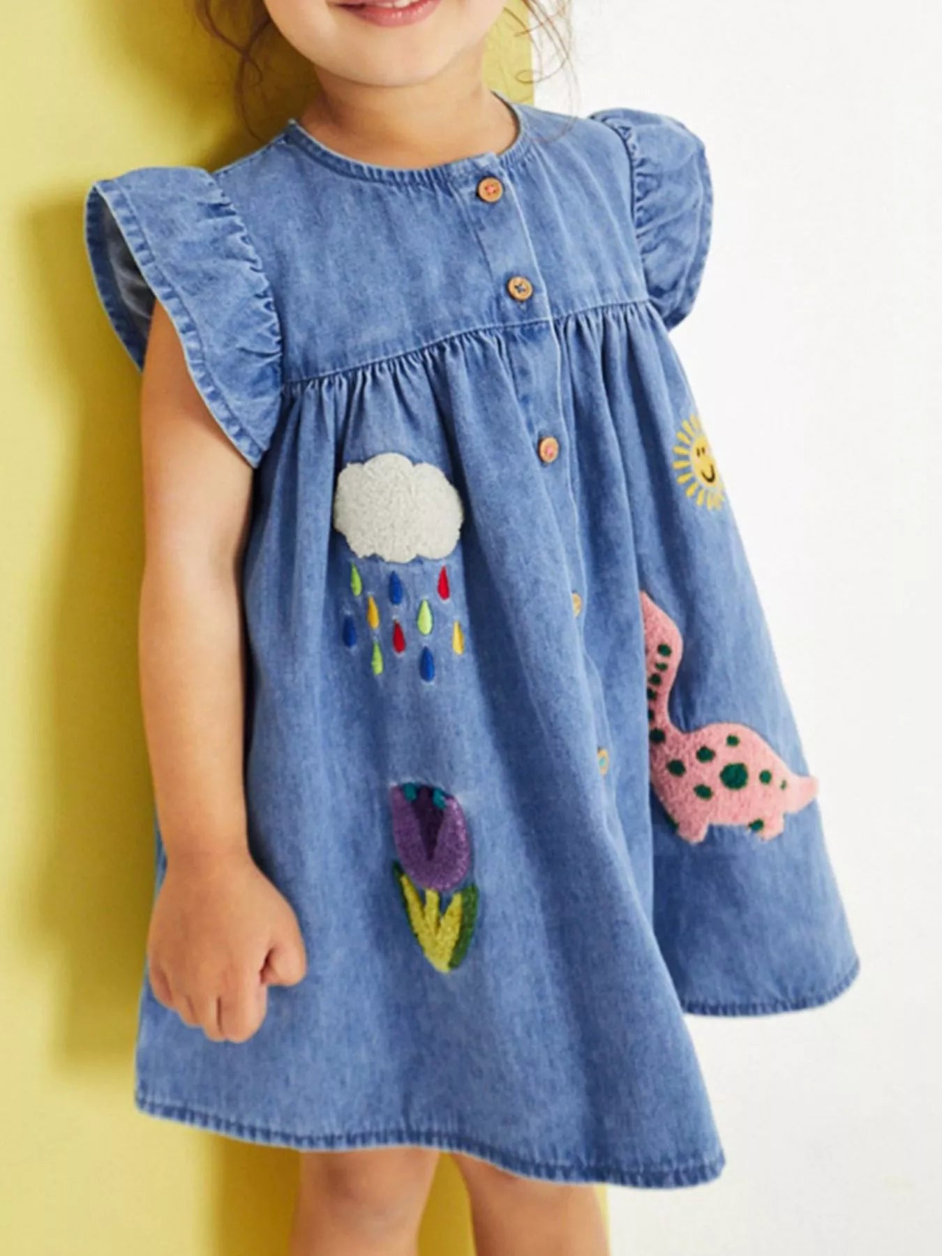 Denim kids A-line dress with dinosaur, rain cloud, flower and sun appliqués, front model view