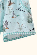 Green duck print kids shorts with gingham hem trim, close-up view