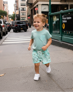 Green duck print kids pocket tee and shorts set, outdoor lifestyle view