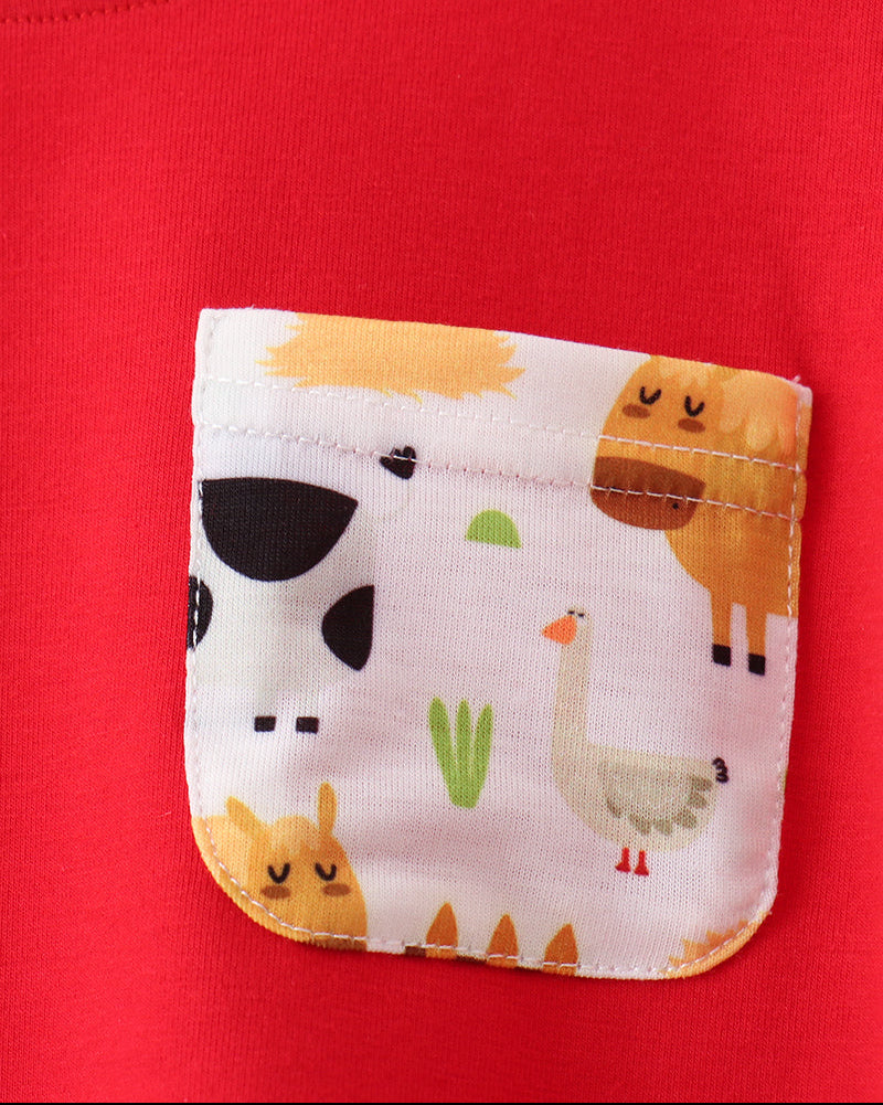 Red kids T-shirt with contrasting farm animal print chest pocket, close-up view