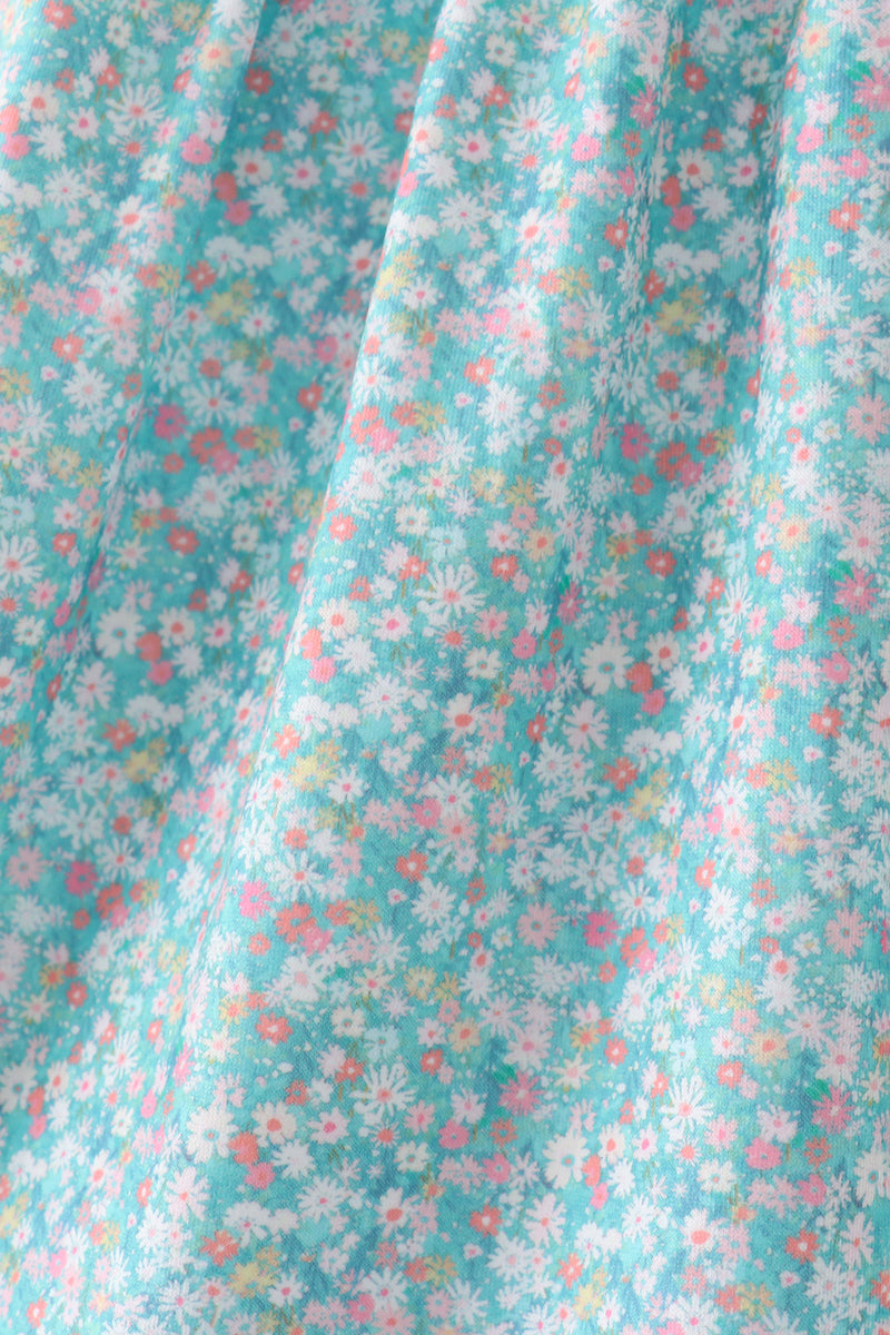 Green floral kids dress with tiny multicolor flower print, fabric close-up view