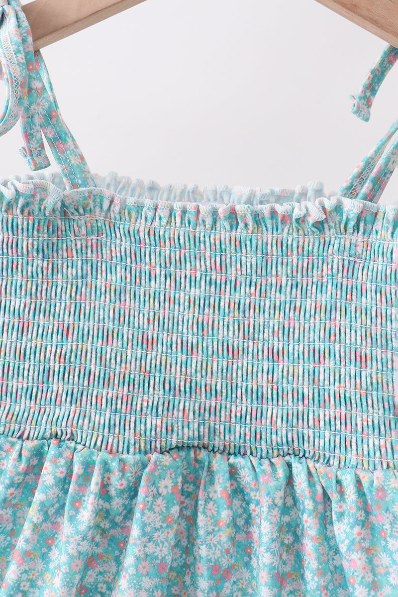 Green floral smocked dress with adjustable bow shoulder ties, upper bodice detail view