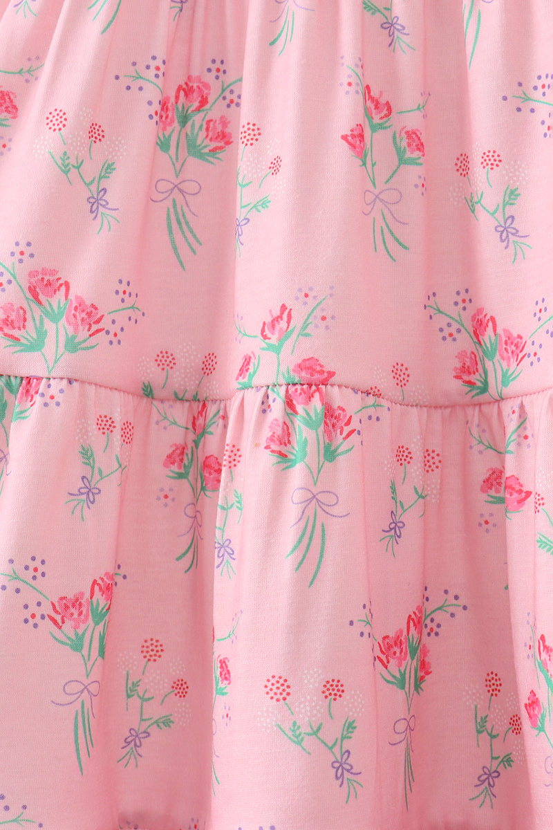 Pink floral kids tiered dress with bouquet print and gathered tier seams, fabric detail view