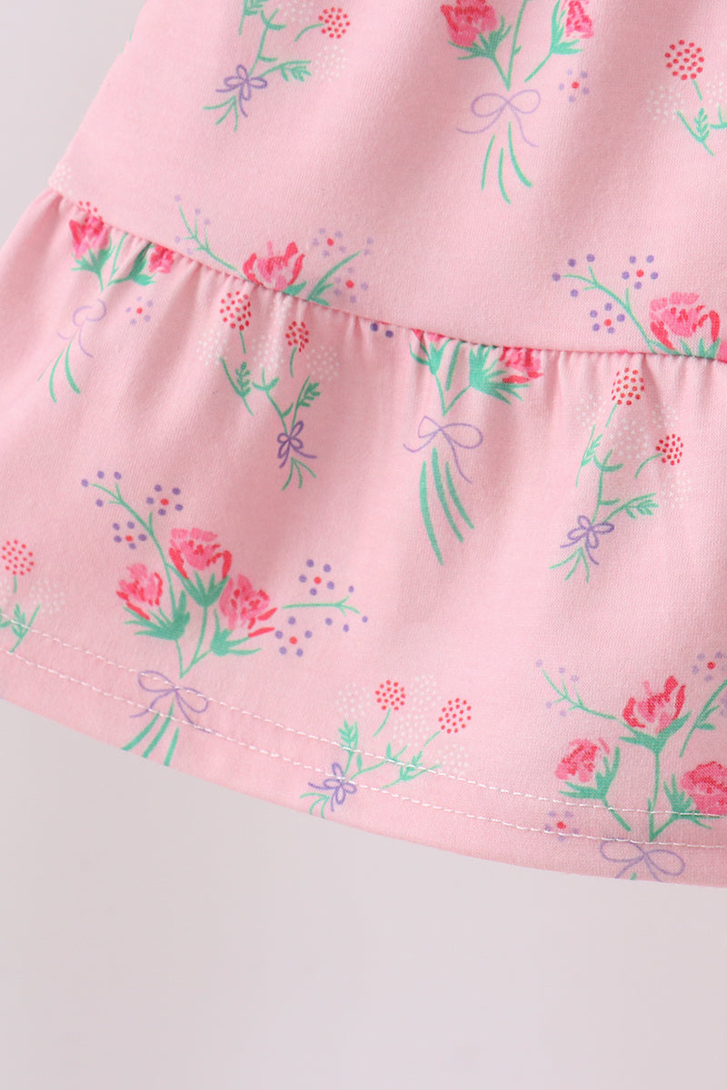 Pink floral kids tiered dress with gathered lower tier and bouquet print, hem detail view
