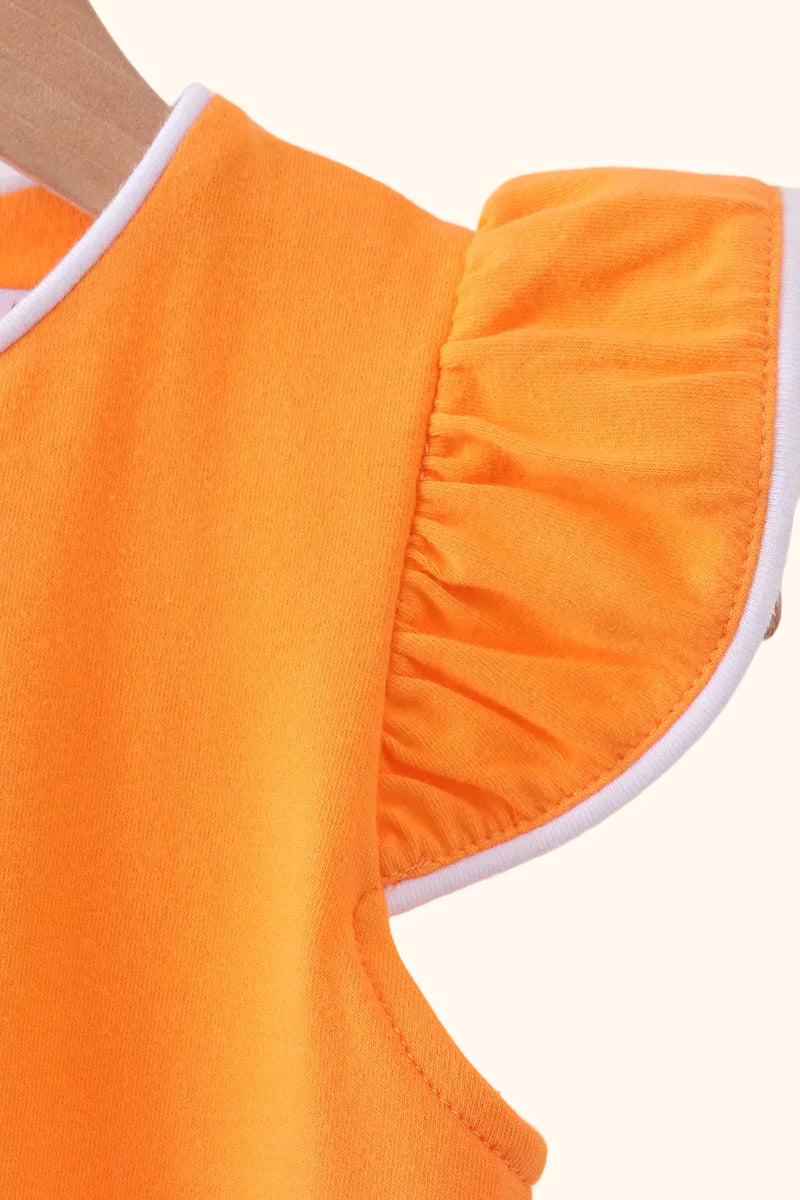 Orange kids top with gathered flutter sleeve and white piping, close-up detail view