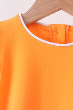 Orange kids top with white-trim round neckline, close-up detail view