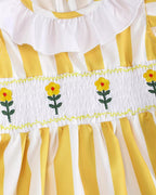 Golden yellow striped baby and toddler ruffle dress with smocked waist and embroidered flowers, detail view