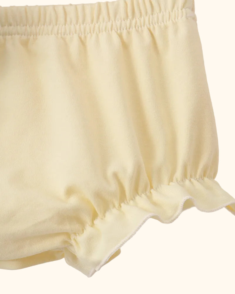 Soft yellow baby bloomers with elastic waist and gathered leg openings, close-up detail