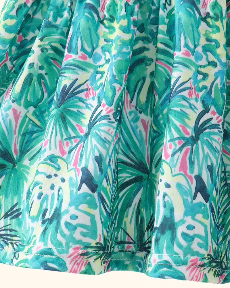 Green baby top with teal, cream and pink tropical leaf print, fabric close-up