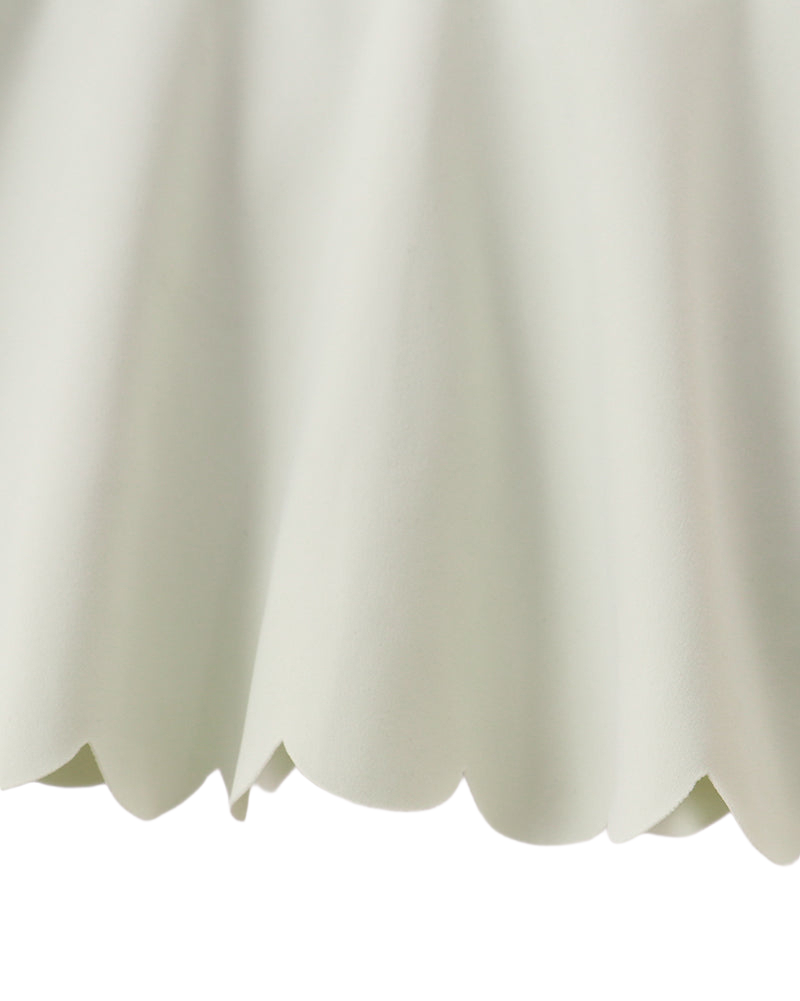 Green kids active skort with scalloped hem and wide waistband, close-up view