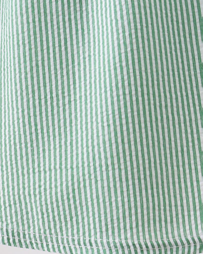 Green and white striped seersucker dress fabric, close-up texture view