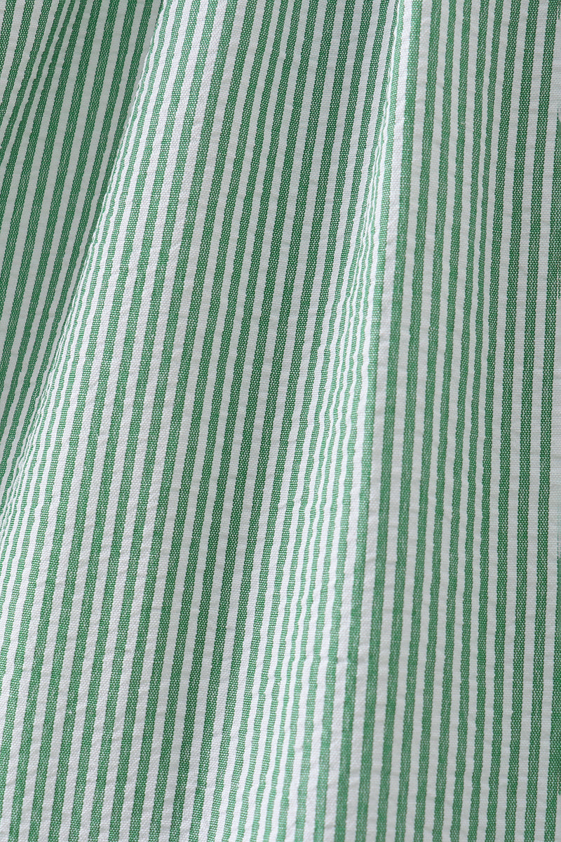 Green and white vertical stripe seersucker fabric, close-up view