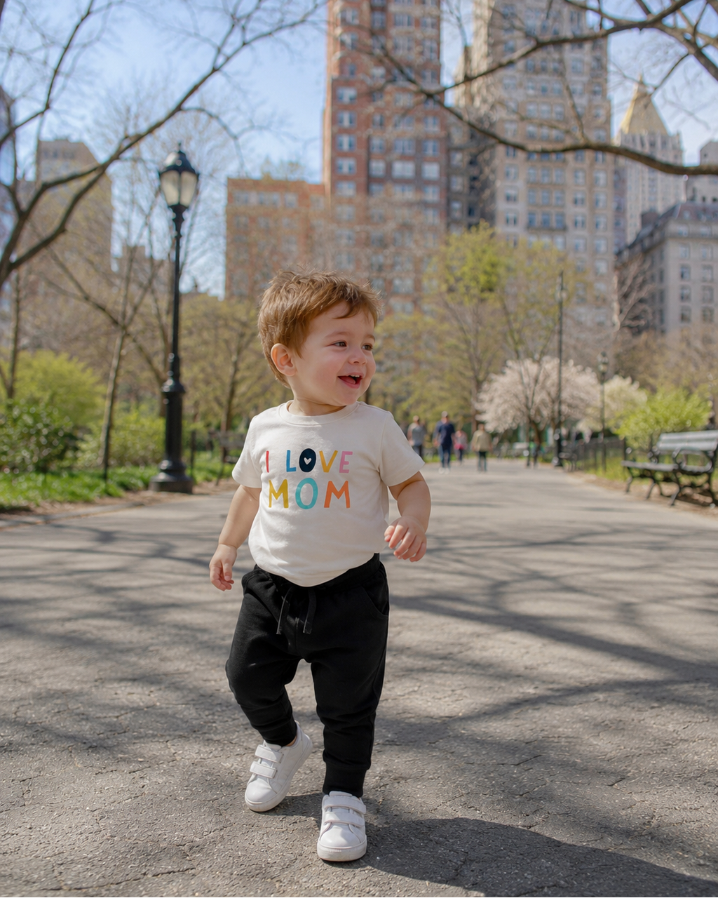 Ivory I Love Mom graphic T-shirt worn with black joggers, front park lifestyle view