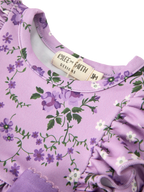 Lavender floral baby romper with purple flowers and round neckline, neckline close-up
