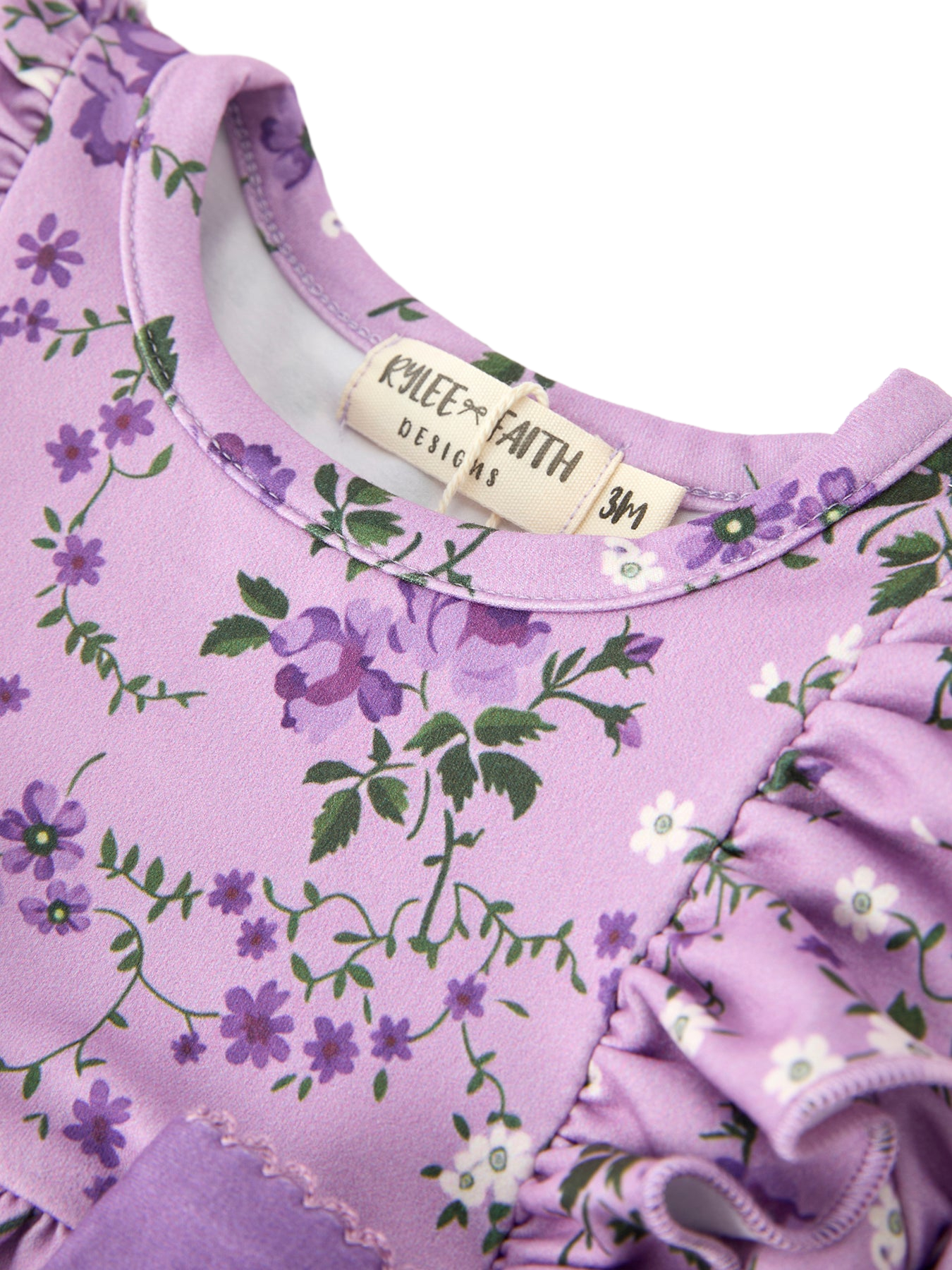 Lavender floral baby romper with purple flowers and round neckline, neckline close-up