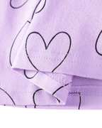 Lavender kids heart print dress with black outline hearts, fabric and hem close-up