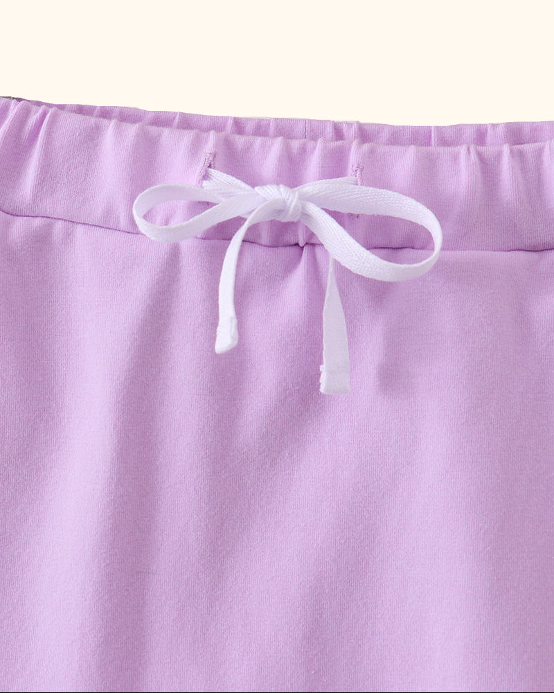 Lavender kids skort with white bow and elastic waistband, close-up front view
