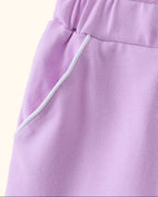 Lavender kids skort with white-piped front pocket, close-up view