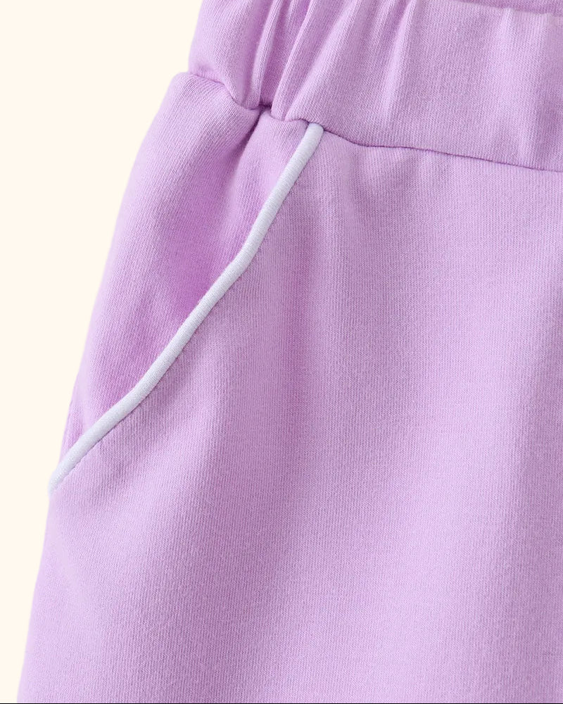 Lavender kids skort with white-piped front pocket, close-up view