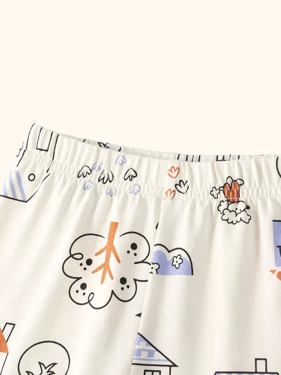 Cream kids printed shorts with houses, flowers and suns, elastic waistband close-up