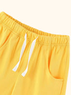 Yellow kids shorts with elastic drawstring waist and front pockets, close-up detail view