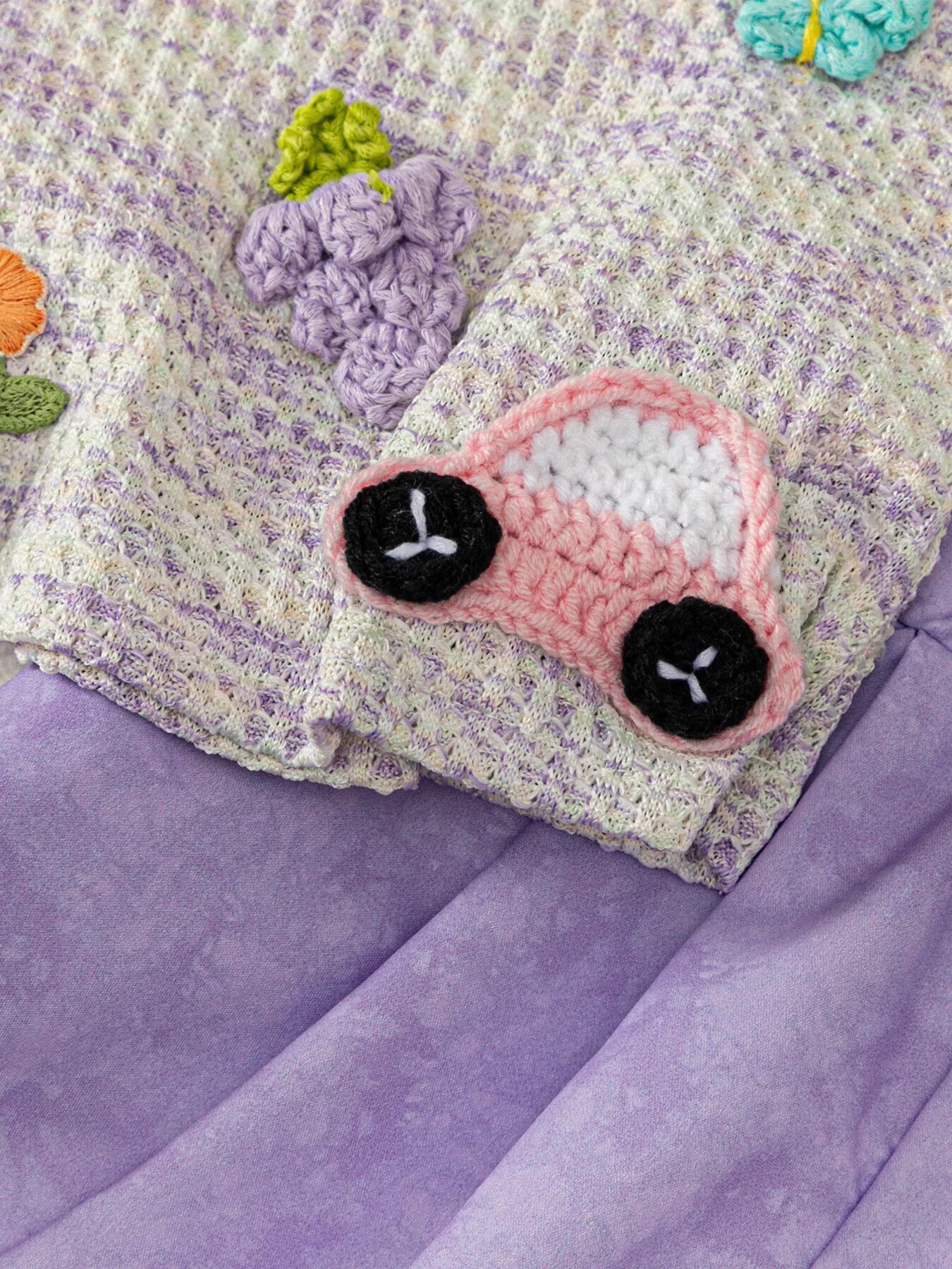 Light purple baby top with purple grape and pink car crochet-style appliqués, close-up view