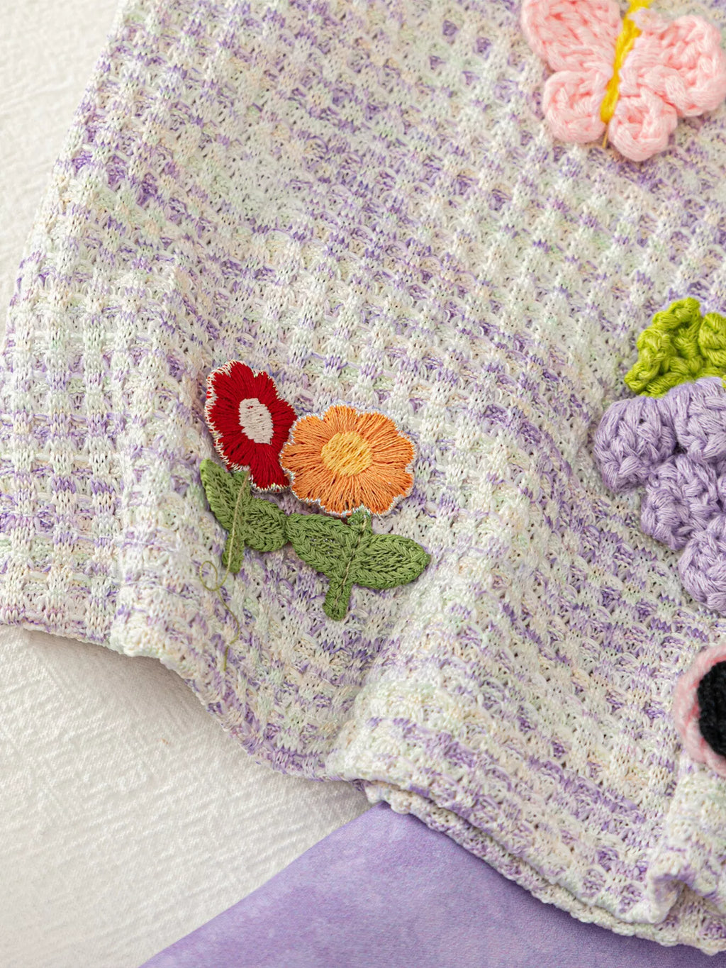 Light purple baby sleeveless top with dimensional butterfly and floral appliqués, detail view