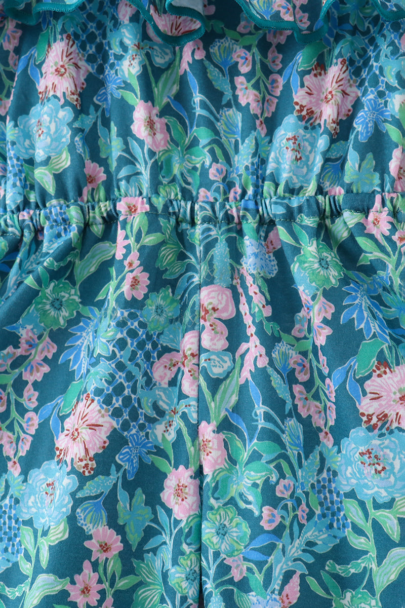 Blue kids floral jumpsuit with pink aqua and green botanical print, fabric and waist close-up