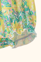 Yellow lily floral baby romper with elasticized ruffle leg opening, detail view