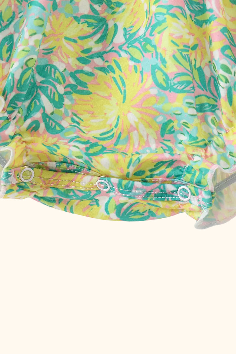 Yellow floral baby romper with snap bottom closure, close-up view