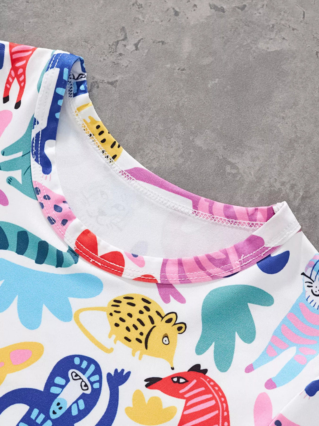 Multicolor kids animal print T-shirt with round neckline and colorful characters, neckline close-up