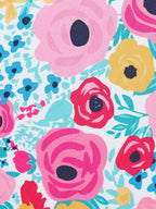 White kids floral print fabric with pink, red, blue and yellow flowers, print close-up