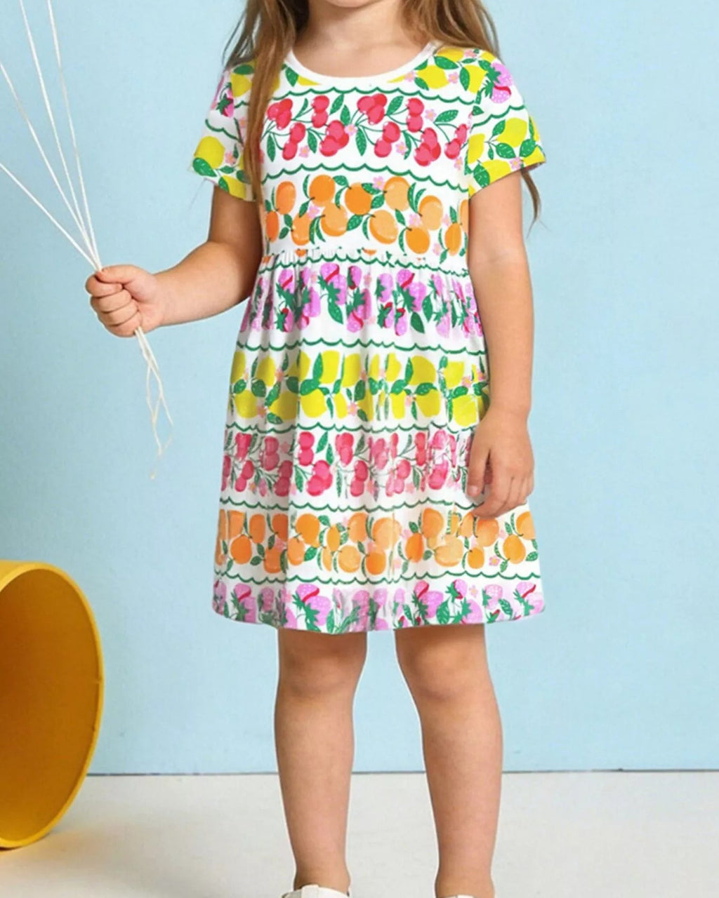 Multicolor kids fruit print gathered dress worn by child, front lifestyle view