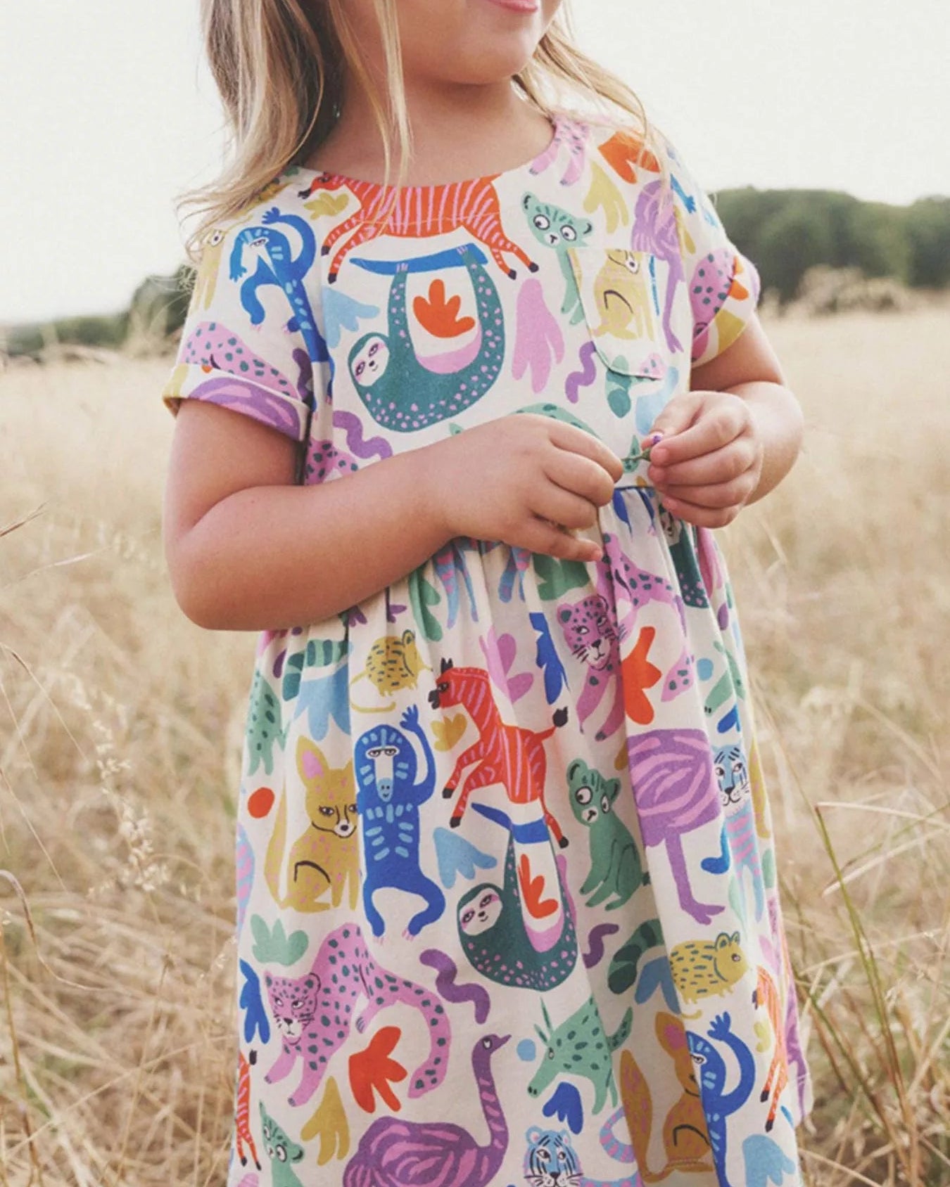 Multicolor kids wild animal print dress worn by child, front lifestyle view