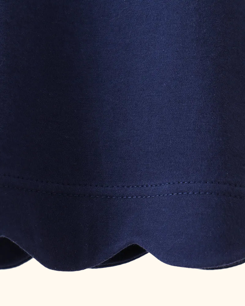 Navy kids flutter sleeve top with scalloped bottom hem, close-up detail view