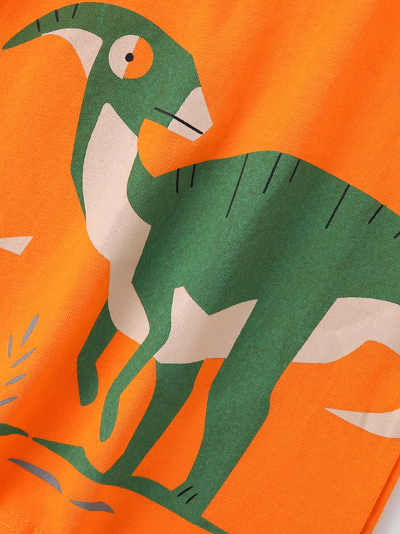 Orange kids T-shirt with green-and-cream dinosaur graphic and black line details, front design close-up