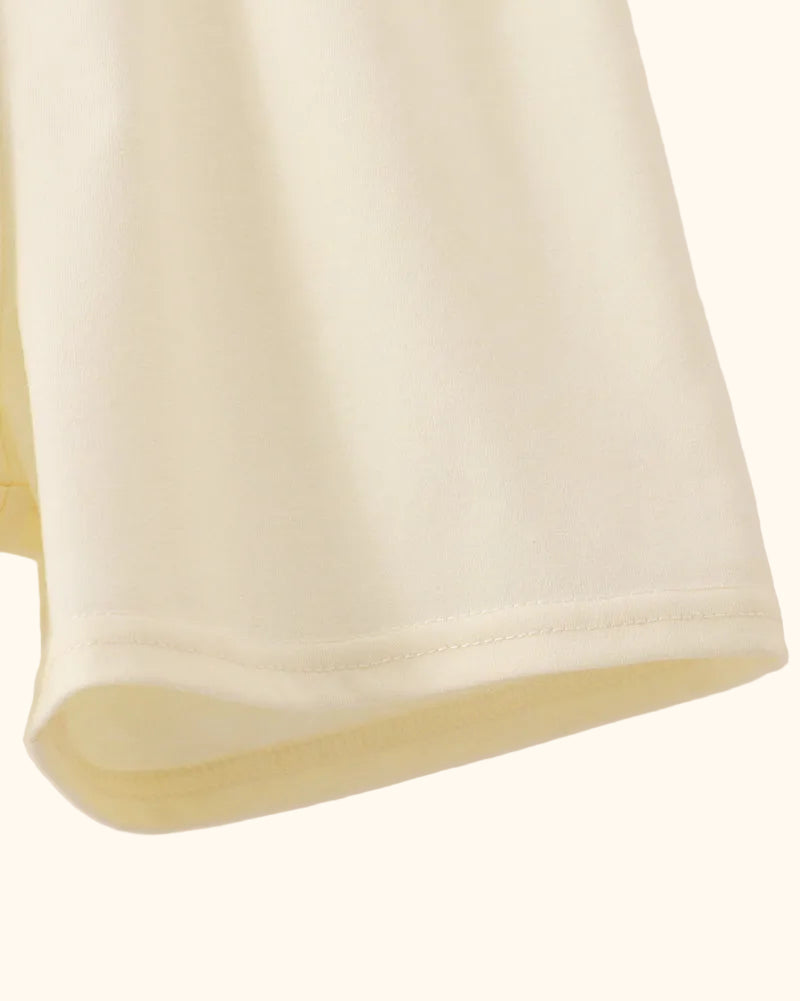 Cream kids shorts with clean stitched hem, close-up view