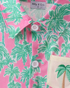 Pink palm tree kids button-down with pointed collar and front buttons, close-up view