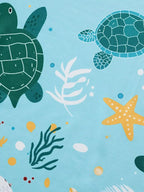 Pastel blue kids ocean print with green sea turtles, starfish and coral, fabric close-up