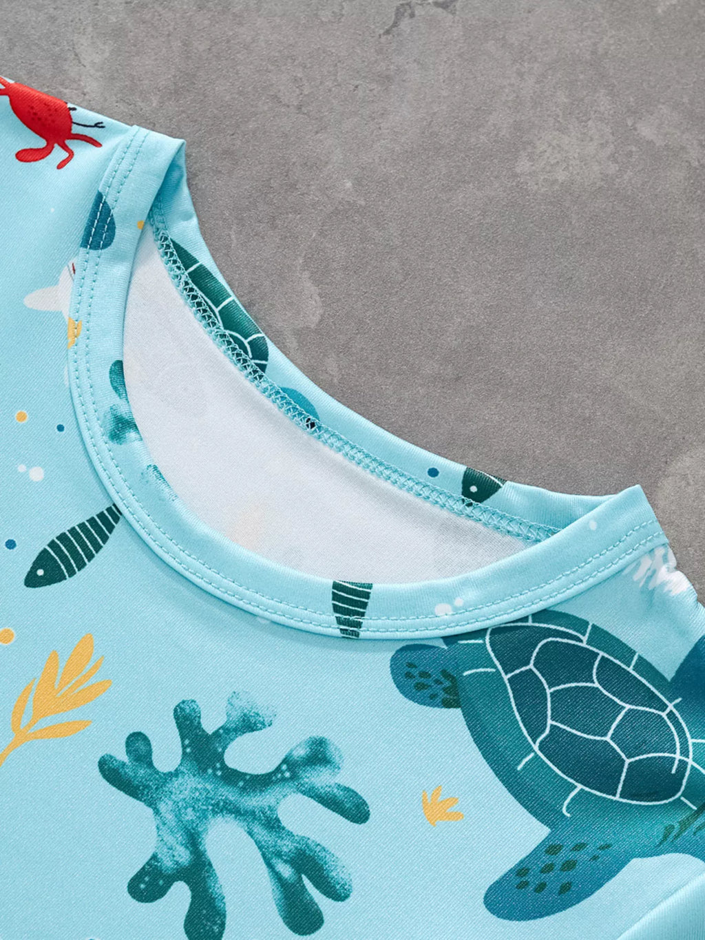 Pastel blue kids sea turtle print T-shirt with round neckline, neckline close-up