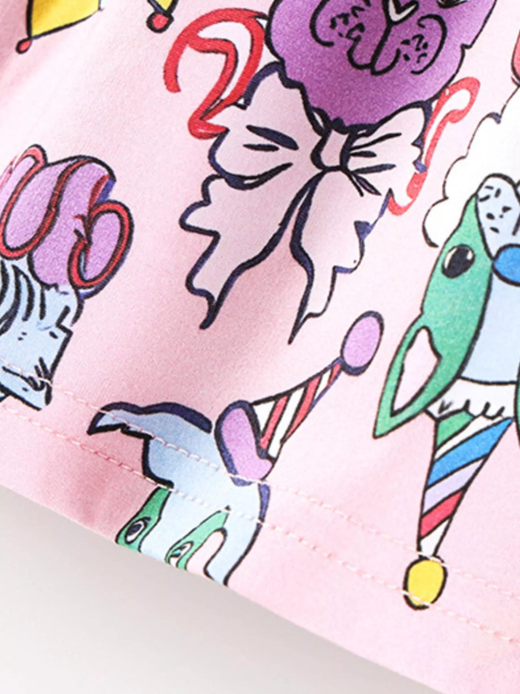 Pink kids animal print dress with colorful cartoon character details, fabric close-up