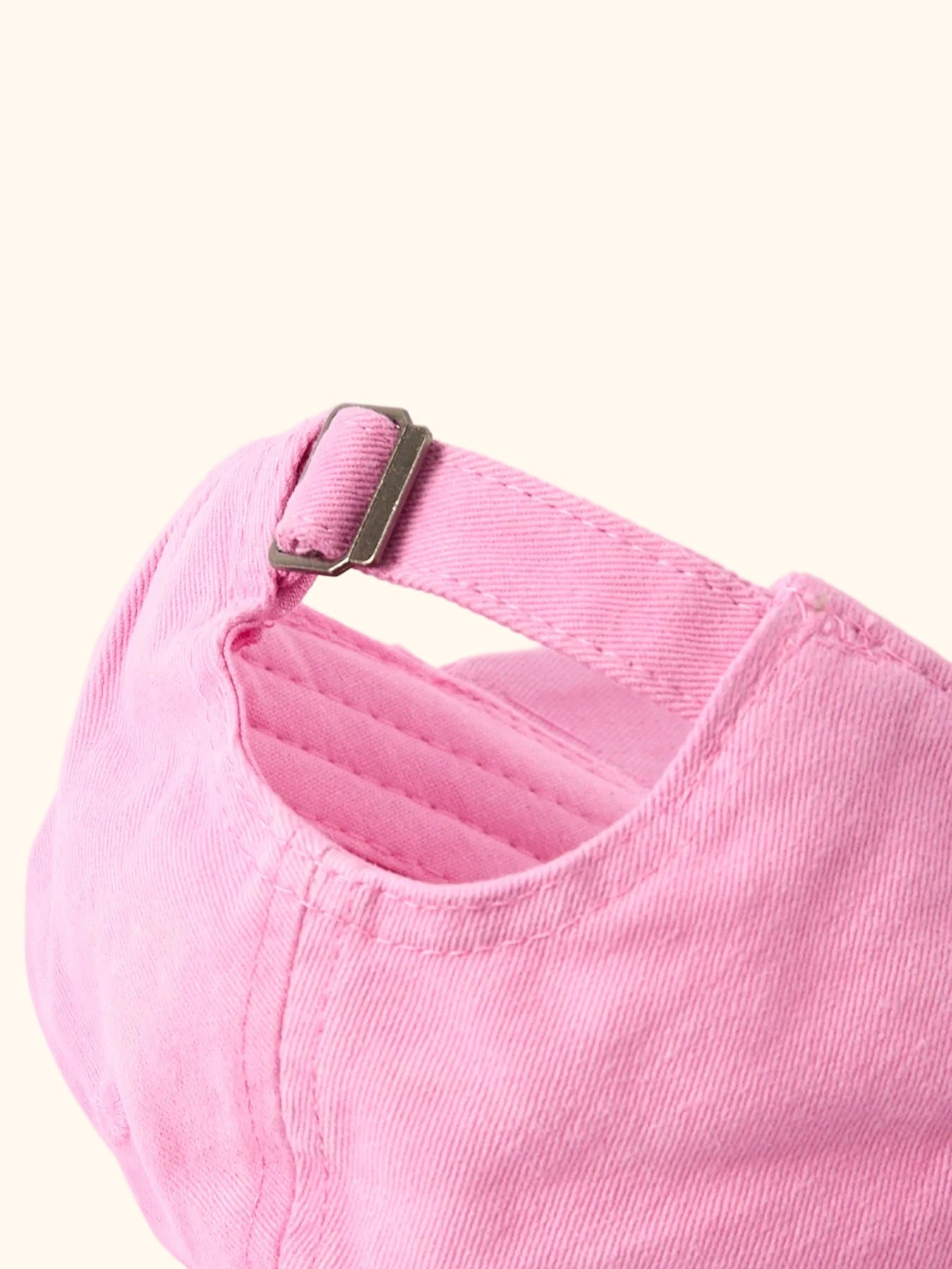 Pink kids cherry baseball cap with adjustable back strap and metal slider, back close-up