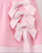 Pink kids skort with three stacked daisy-print bows, close-up detail view