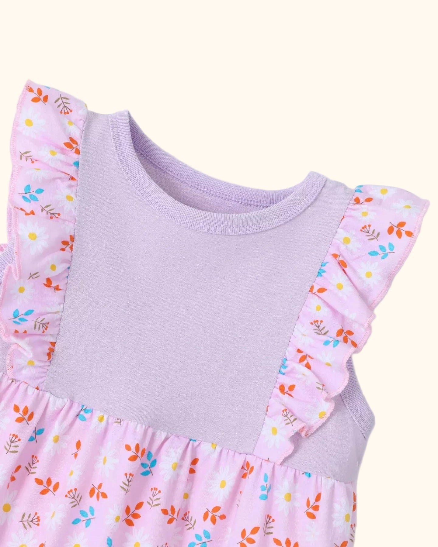 Pink kids floral dress with round neckline and flutter ruffle shoulders, bodice close-up