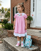 Pink gingham school bishop dress with full gathered silhouette, modeled front view