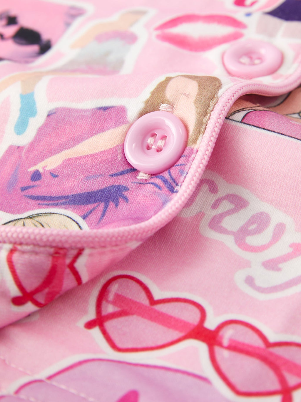 Pink kids music collage pajama top with pink button and piped front edge, closure close-up
